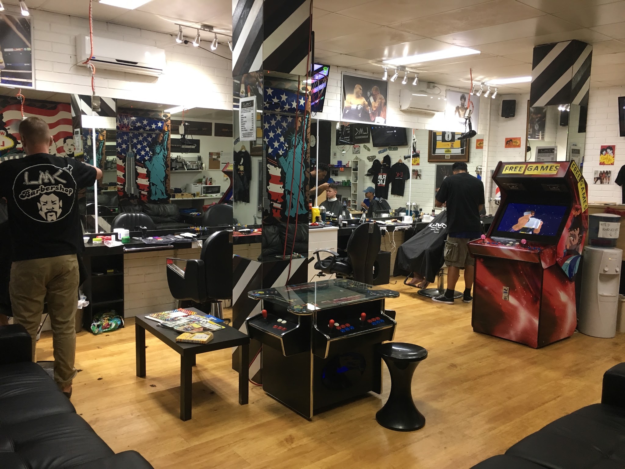 Inside LMC's Barbershop: barber chairs, mirrors, an American flag mural and arcade machines